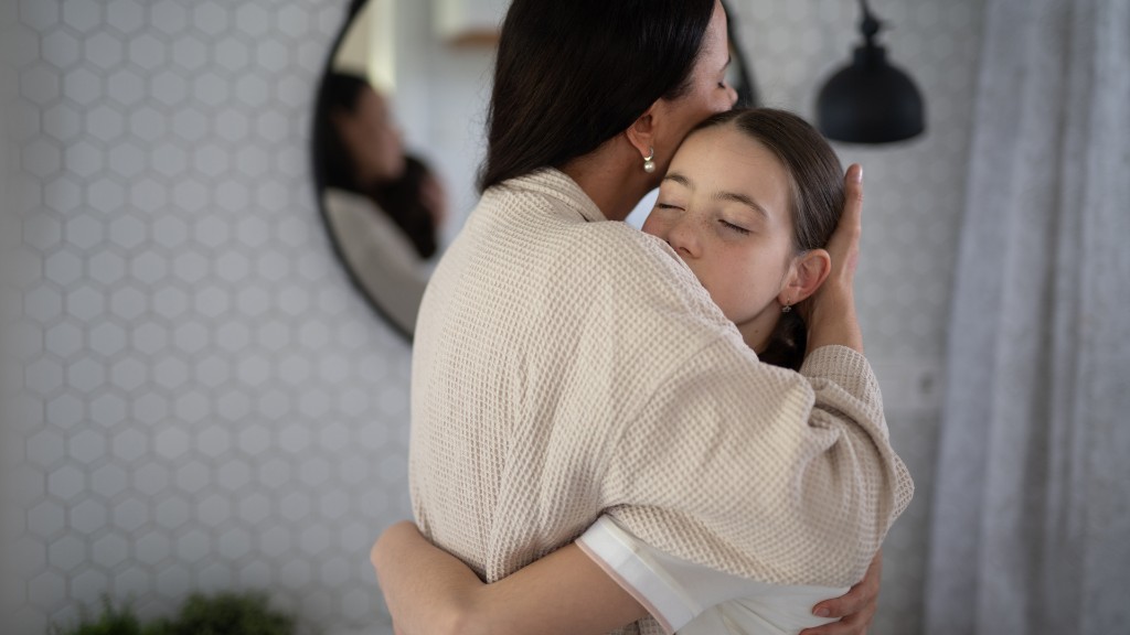 A mother gently hugging her daughter in a comforting embrace at home