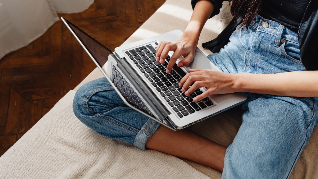 A person sitting on a couch with a laptop open, in a relaxed telehealth-style live session setting