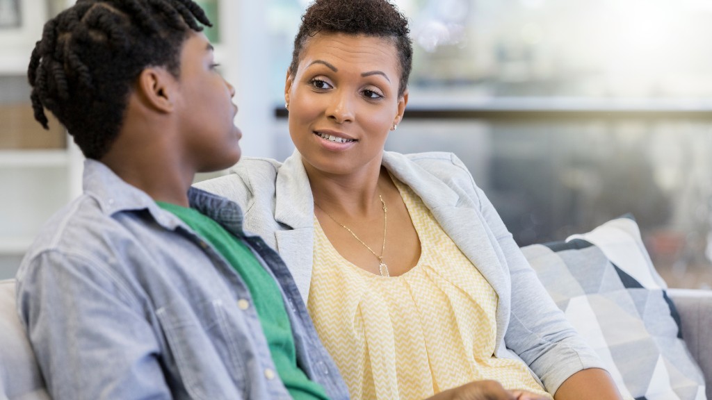 A woman and teenage boy sitting on a couch in calm, focused conversation